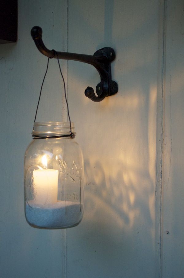 Mason jar votive candle holders at night. Sand and...