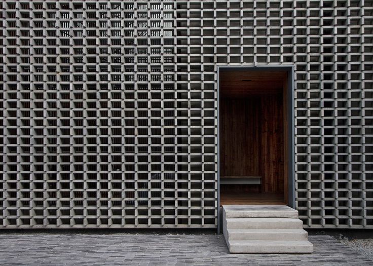Overlapping bricks give a perforated facade to thi...