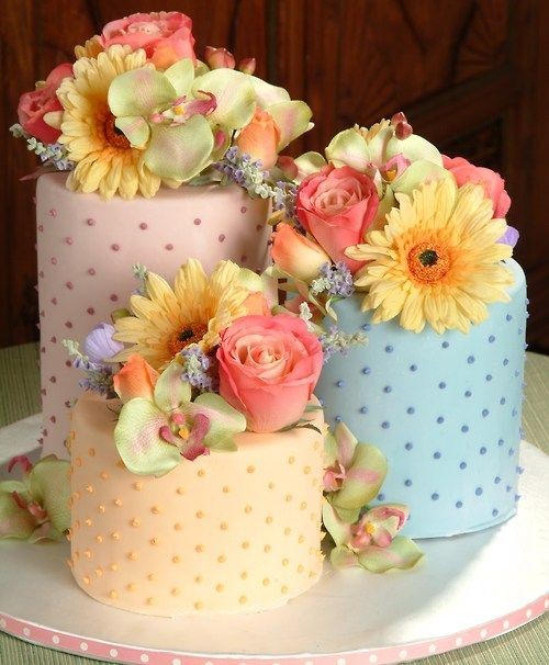 A trio of dotted swiss cakes topped with flowers