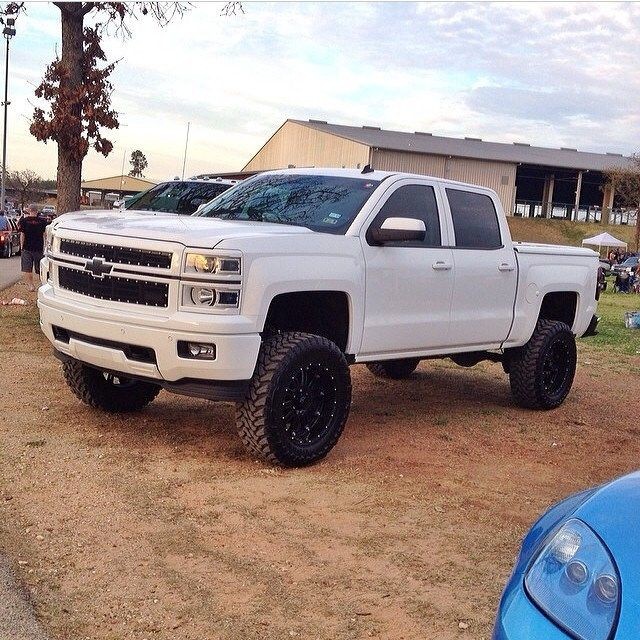 White lifted Chevrolet Silverado truck with Chevy...