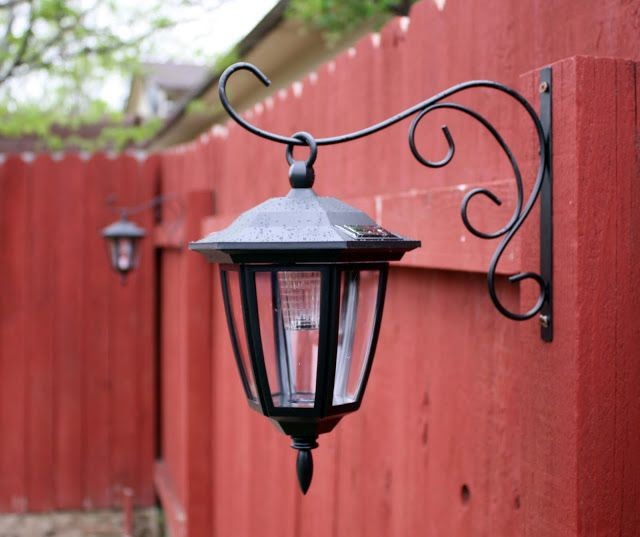 Solar lights hung on plant hangers for your fence....