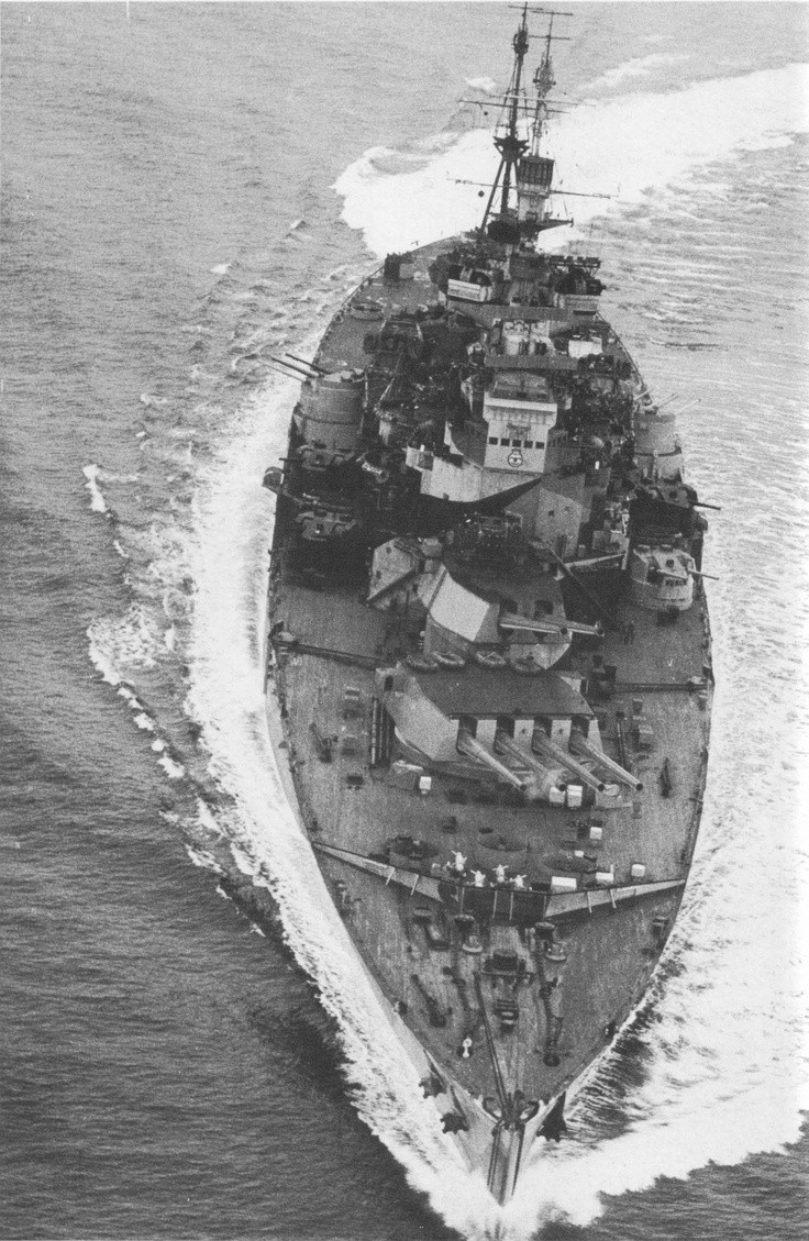 Battleship HMS Howe maneuvers off Okinawa with her...