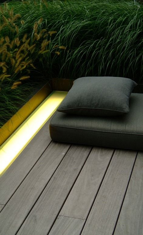 Wooden terrace with integrated lighting cove. Land...