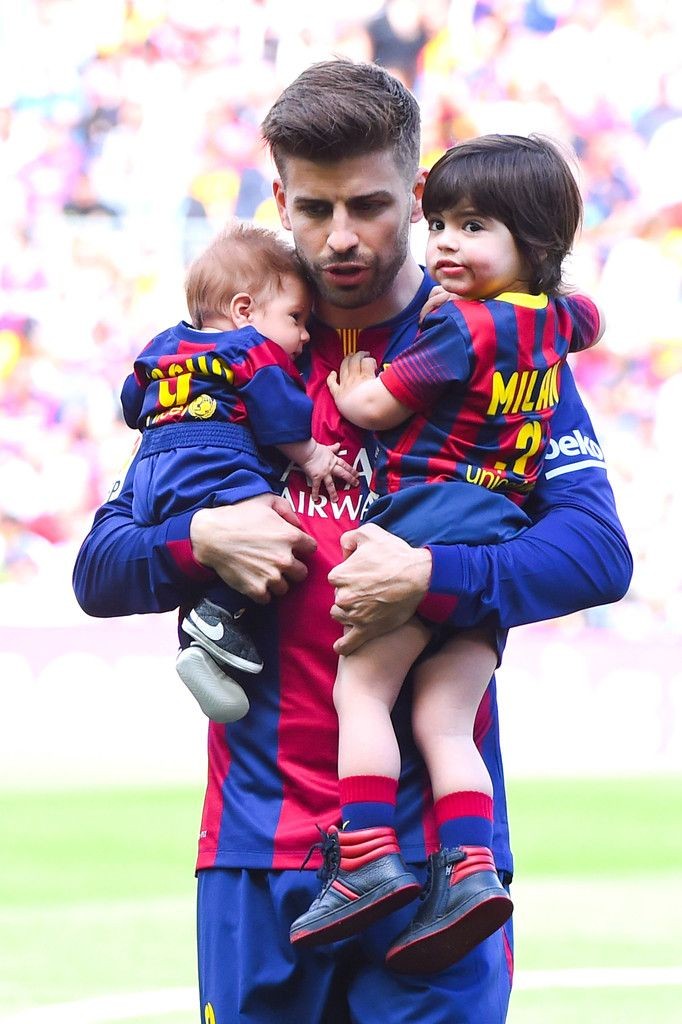 Gerard Pique of FC Barcelona carries his sons Sash...