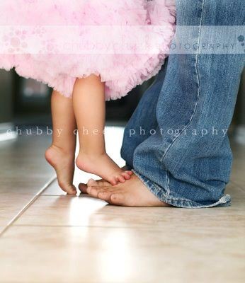 Take a picture of daughters on daddys feet as a in...