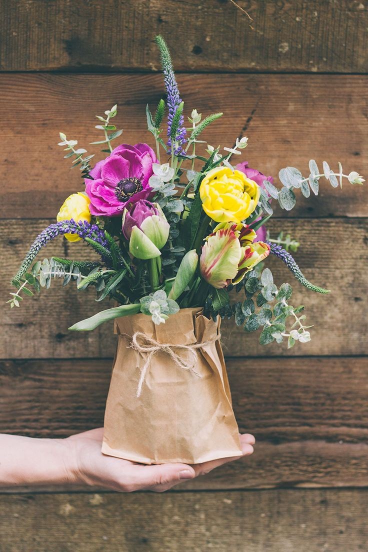 Pop beautiful flowers in a paper bag and tie with...