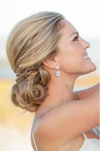 A low chignon with a delicate braid wrap is a chic...