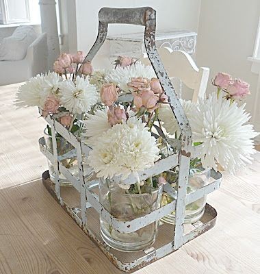 Love this shabby carrier with jars of flowers!