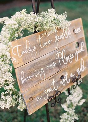 Rustic wood with white lettering, framed by baby's...
